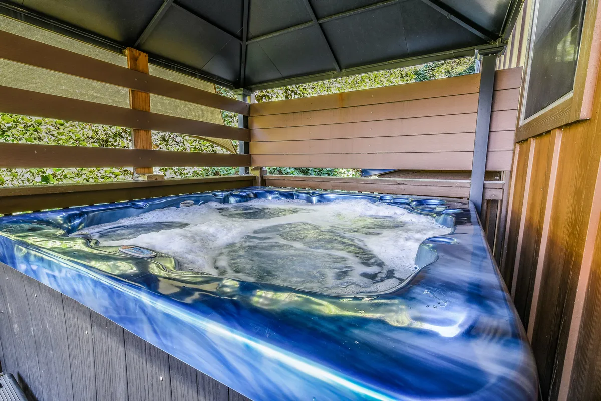 A tranquil hot tub nestled within a wooden enclosure, inviting guests to relax and unwind. The scene is perfect for post-adventure downtime, socializing, or stargazing in comfort.