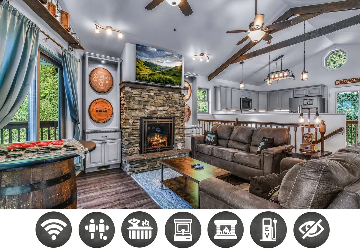 The image showcases a warm and inviting living room with a striking stone fireplace as the centerpiece, a plush sectional sofa perfect for lounging, a large TV for entertainment, and a rustic wooden barrel table, all set against the backdrop of a cozy, wood-accented interior.