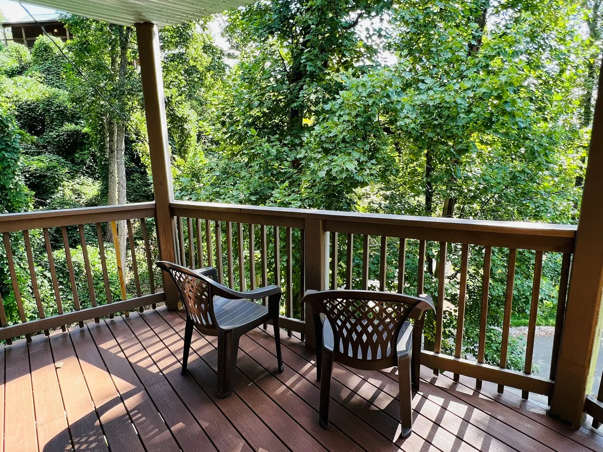 This image features two chairs on a deck, surrounded by lush greenery. The setting is peaceful and intimate, perfect for relaxing, reading a book, or savoring a morning coffee while enjoying the natural mountain surroundings.